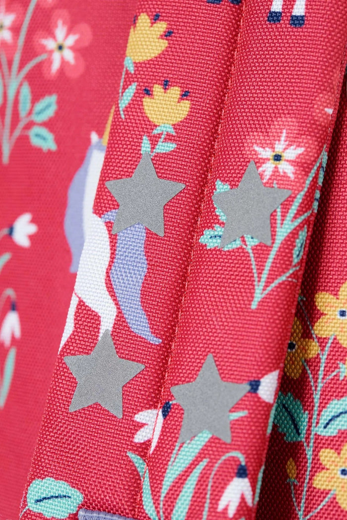Close-up of a fabric with stars, flowers, and animals on a red background