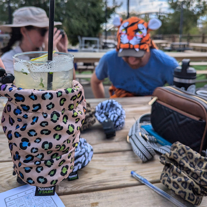 Leopard print cup holder with other cup holders and holding a mojito