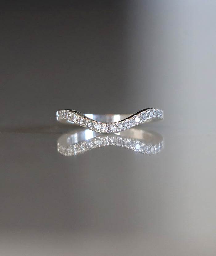 Ring i silver med ett band av små diamanter på rad.