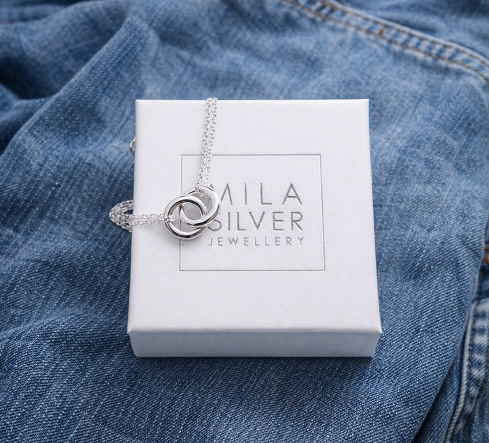 Silverarmband med ringar placerade på en vit ask från Mila silver