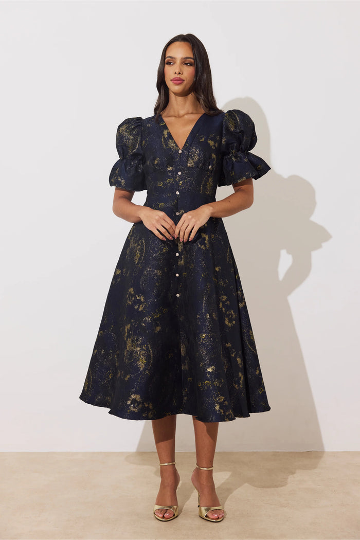 Model wearing 8th Sign Callie Button Dress Midnight Blue Gold with puff sleeves. Shop 8th Sign at Dotique.