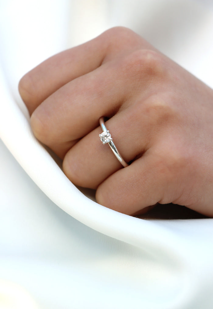 Tjej som bär en förlovningsring i silver med diamant.