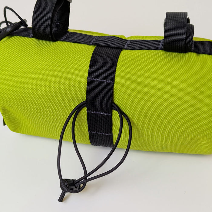 back view of green handlebar bag with bungee strap