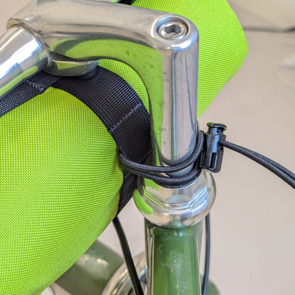 back view of green handlebar bag on bike with bungee strap