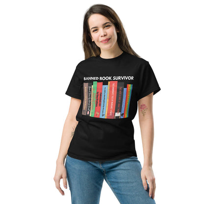 A person wearing a black unisex t-shirt with a graphic of colorful books and the text 'BANNED BOOK SURVIVOR' on the front.