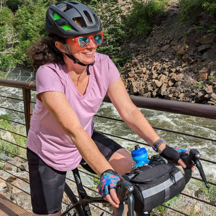Cyclist by a river using a handlebar bag.