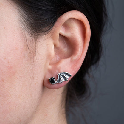 Worn on the earlobe, the 16mm bat wing sweeps back across the ear with the black stone sitting forward