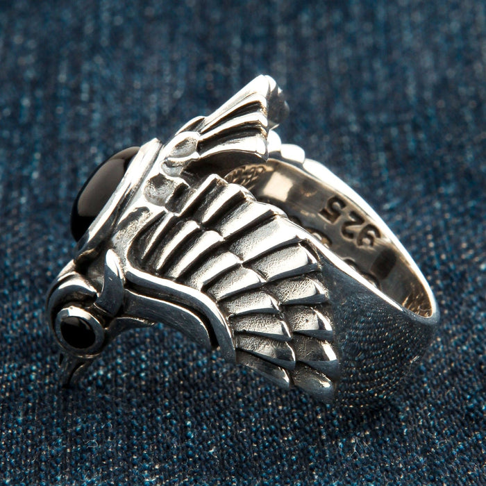 A close-up macro shot of the detailed, oxidized feather carvings on the silver phoenix ring.