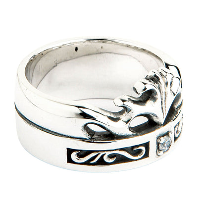 Detail of the sculpted silver crown top edge above a recessed oxidized knotwork channel and cubic zirconia stone.