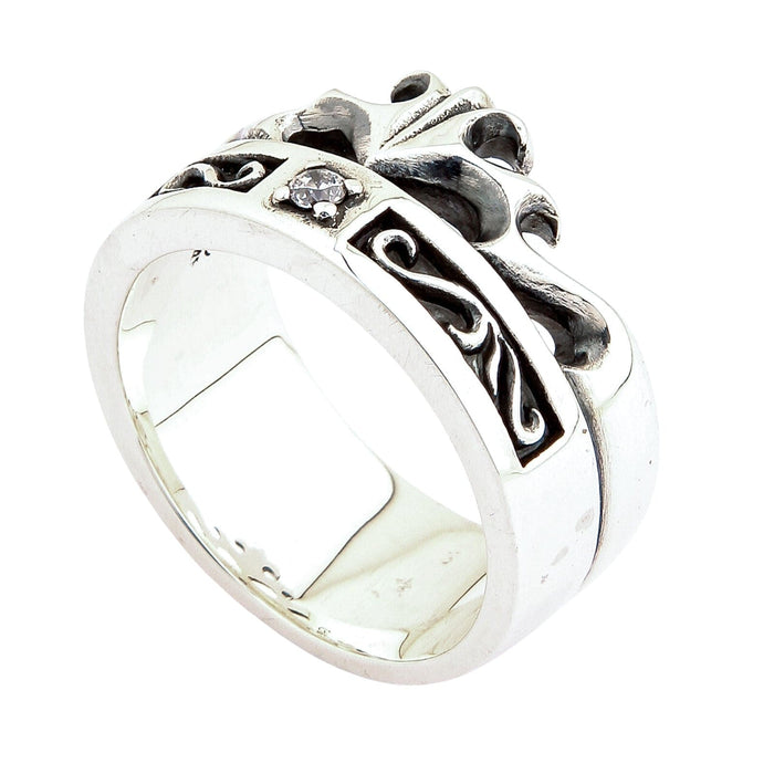 Tilted silver ring highlighting the smooth lower band beneath the oxidized crown knotwork and clear center stone.