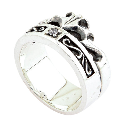 Tilted silver ring highlighting the smooth lower band beneath the oxidized crown knotwork and clear center stone.