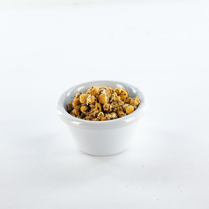 Dried chamomile tea in a white bowl