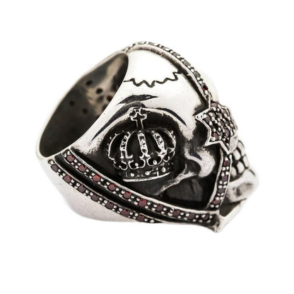 Angled view of the crown skull ring featuring a red garnet star eye patch and detailed silver carving.