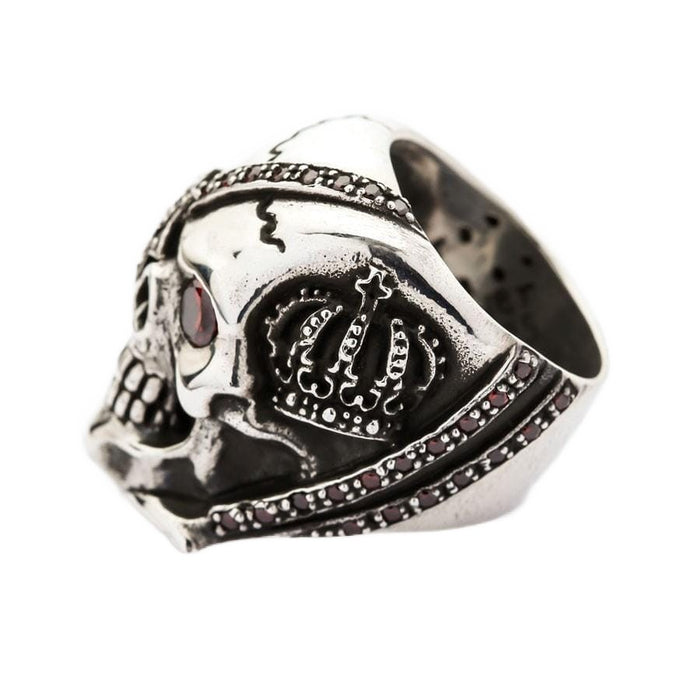 Side profile of the heavy silver skull ring highlighting the royal crown motif and red cubic zirconia accents.