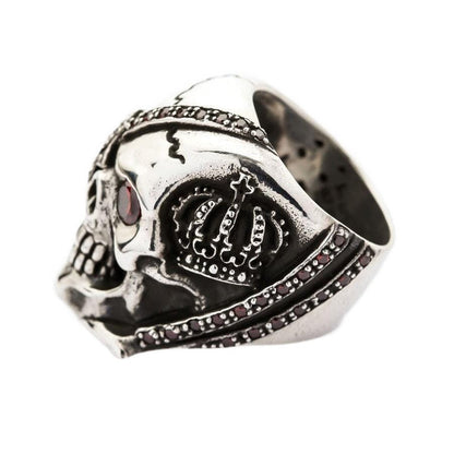 Side profile of the heavy silver skull ring highlighting the royal crown motif and red cubic zirconia accents.