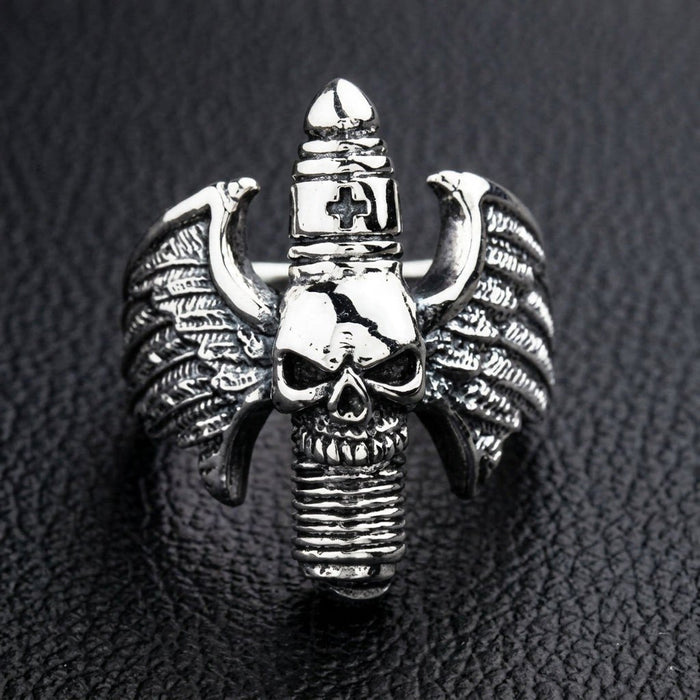 Detailed close-up of the oxidized silver skull and feathered wings, featuring a unique vertical ribbed design with a cross.