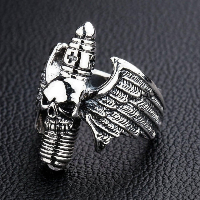 Side angle of the solid silver statement ring emphasizing the textured right wing and central skull.