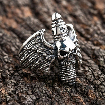 Angled view of the gothic statement ring displaying the central skull, textured wings, and ribbed cross detail on a wood surface.