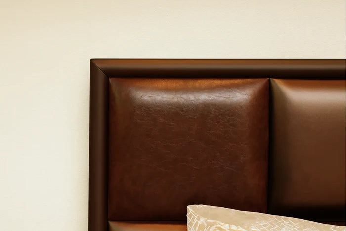 Brown padded bed headboard with quilted panels and top edge of bedding