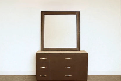 Brown dresser with drawers and a matching framed mirror
