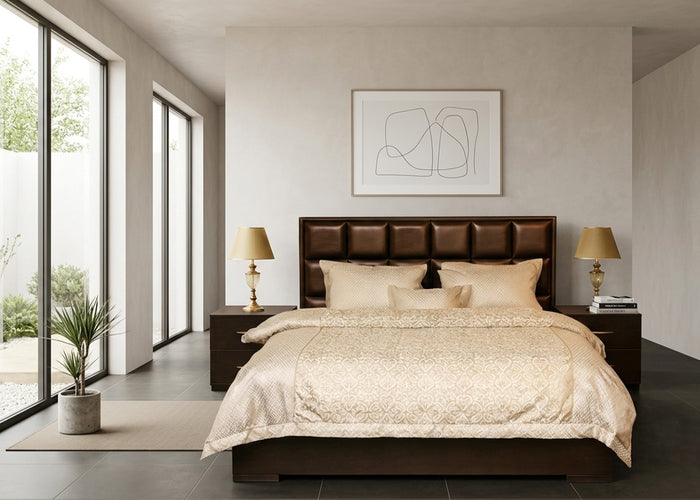 Brown upholstered bed with paneled headboard, two side tables, and beige bedding