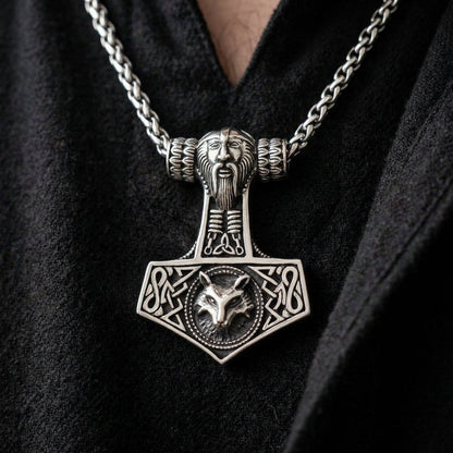 Sterling silver Mjolnir pendant worn on a chain, featuring Thor's face on the handle and Fenrir the wolf on the base.