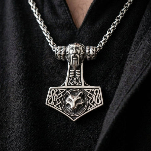 Sterling silver Mjolnir pendant worn on a chain, featuring Thor's face on the handle and Fenrir the wolf on the base.