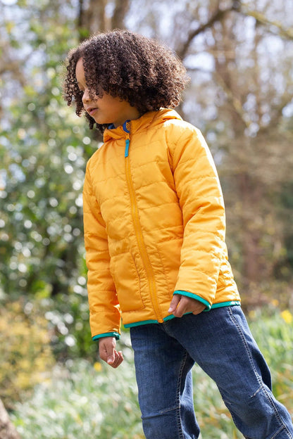Child wearing a yellow puffer jacket in a natural setting