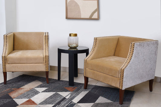 Beige upholstered accent chair with dark wood legs and nailhead trim, side view