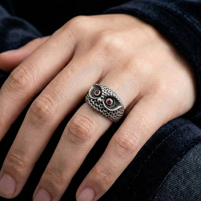 Handcrafted sterling silver owl ring with garnet eyes worn on hand showing fit and scale