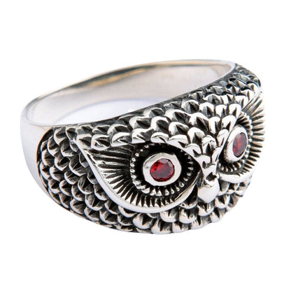 Side angle view of sterling silver owl ring showing intricate feather carving and garnet eye detail