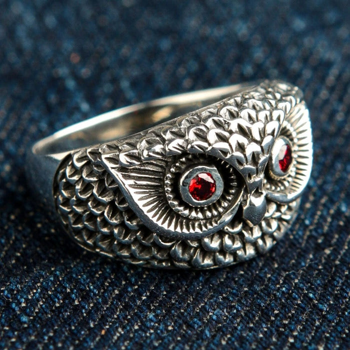 Right side detail of handcrafted owl ring showing layered feather texture and garnet gemstone