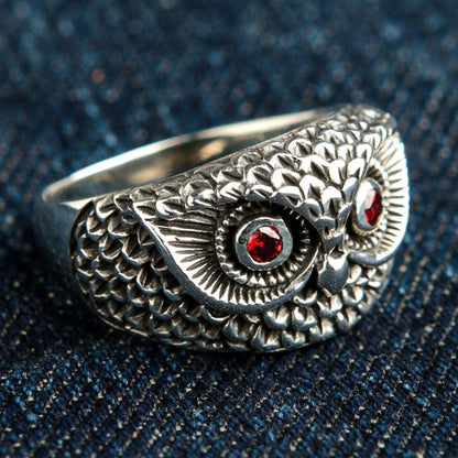 Right side detail of handcrafted owl ring showing layered feather texture and garnet gemstone