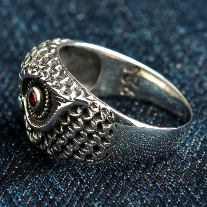 Side profile of sterling silver owl ring highlighting hand-carved feather pattern and band width