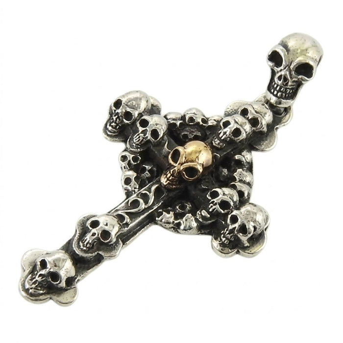 Tilted angle showcasing the intricate sterling silver skull carvings and contrasting gold center of the cross.
