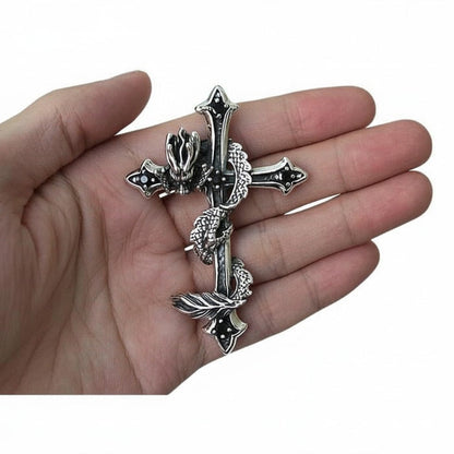A hand holding the large 25-gram dragon cross pendant to show its massive scale.