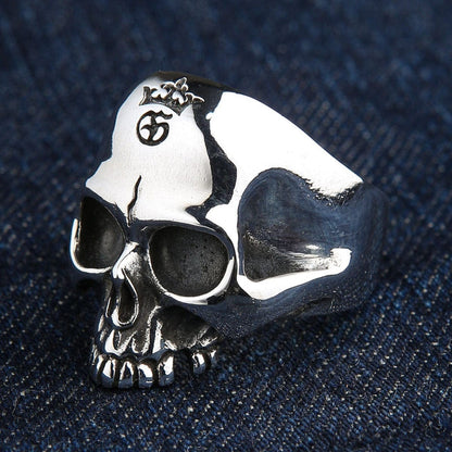 Three-quarter angle of the heavy .925 silver biker ring on denim, showcasing the thick tapered band and deep eye sockets.