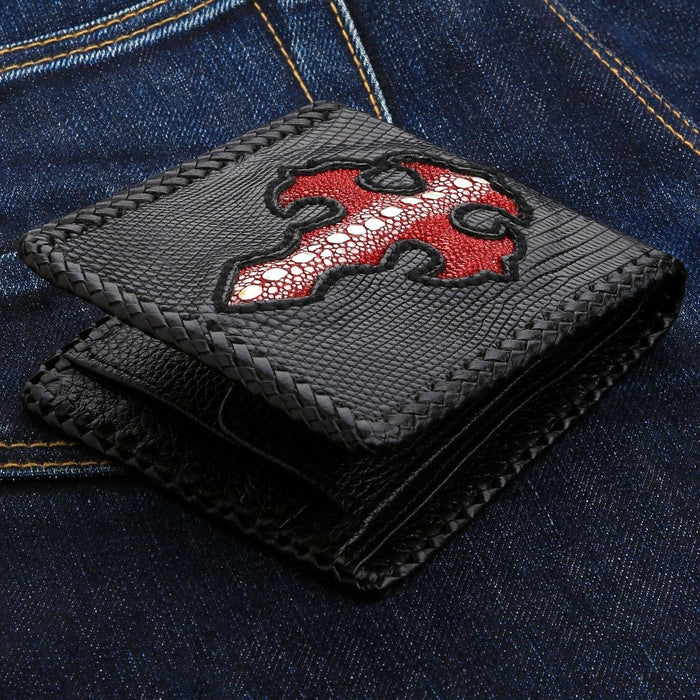 The black lizard skin biker wallet with braided leather edges, resting on blue jeans.