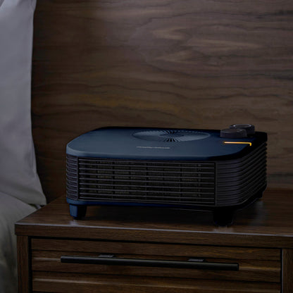 Black heater on a wooden nightstand with a blurred background