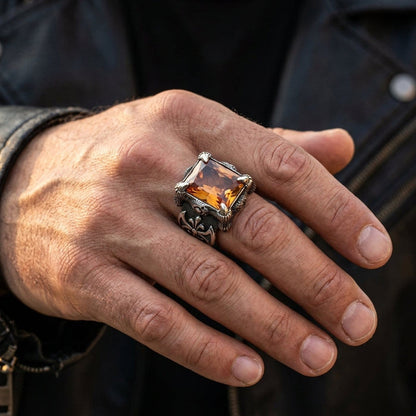 Man's hand wearing the massive sterling silver Imperial Topaz dragon claw ring against a black leather biker jacket