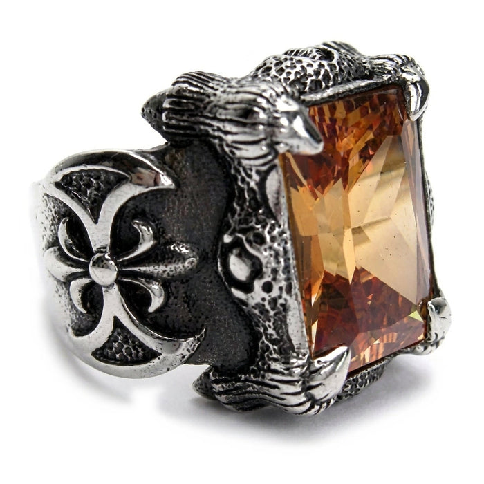Angled view of the fleur-de-lis shoulder and cognac imperial topaz stone on the sterling silver dragon claw ring