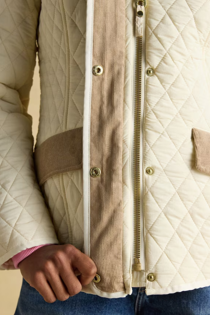 Shop the Joules Highclere showerproof diamond quilted jacket — a stylish and practical layer with cord collar, welt pockets and adjustable waist, perfect for rainy days. Shop Joules at Dotique.