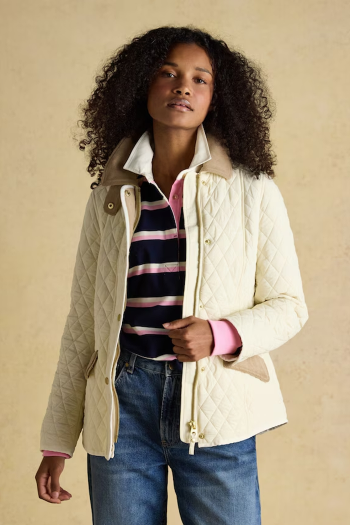 Shop the Joules Highclere showerproof diamond quilted jacket — a stylish and practical layer with cord collar, welt pockets and adjustable waist, perfect for rainy days. Shop Joules at Dotique.