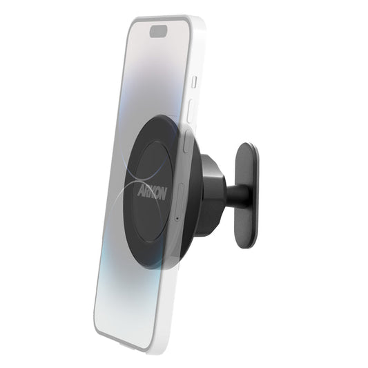 The Magnetic Phone Holder with Adhesive Mount - MagSafe Compatible securely holds a smartphone vertically on a wall. Its round, black “ANKON” face uses strong 3M VHB adhesive for reliable placement.