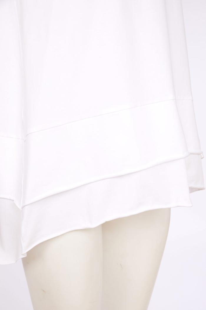 White Naya cami top with wide straps, layered raw hem and back vent. Soft, flattering and perfect for layering. Shop at Dotique.