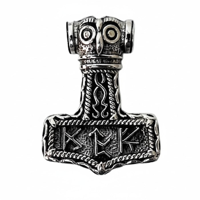 A front view of the Thor's hammer pendant, featuring an owl face and Elder Futhark style runes.