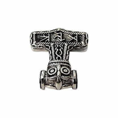 A close view of the owl's round eyes and pointed beak on the runic Mjolnir pendant.