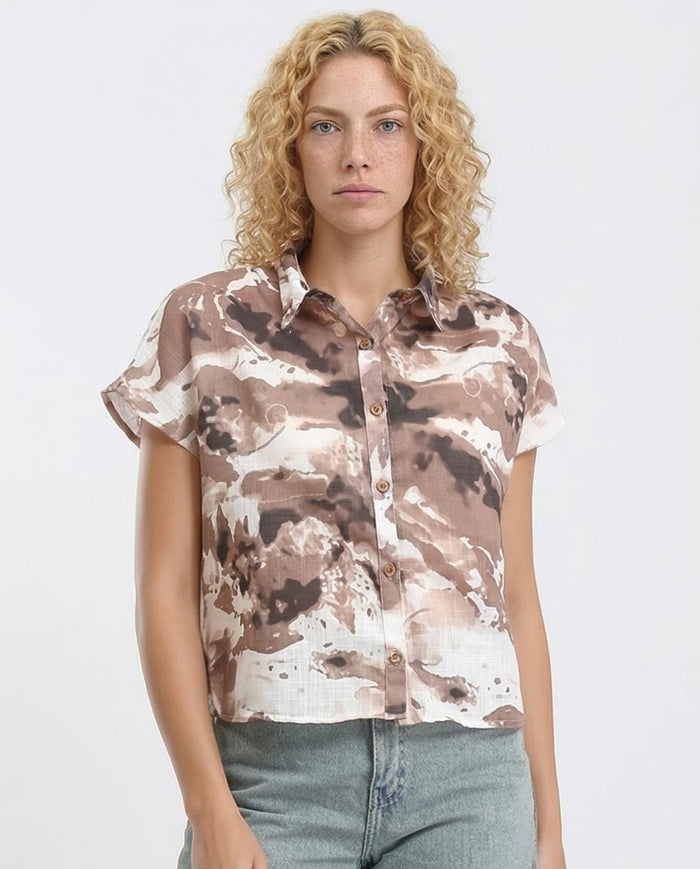 Woman wearing a patterned shirt against a plain background