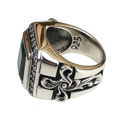 The side profile of the gothic floral cross ring, highlighting its intricate, hand-carved details and green stone.