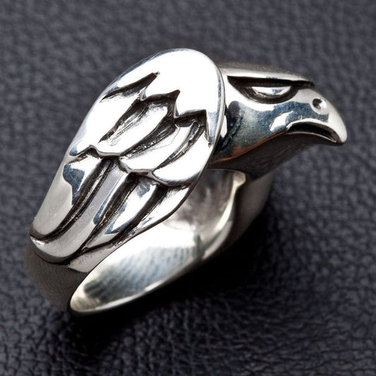 Side profile of handcrafted silver hawk ring highlighting sculpted wing feathers and smooth band
